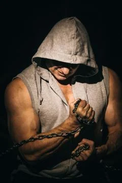 Athletic young man with chains on his fists Stock Photos