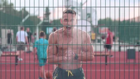 Athletic young man claps hands walking around basketball court looking straig Stock-Footage 159478145