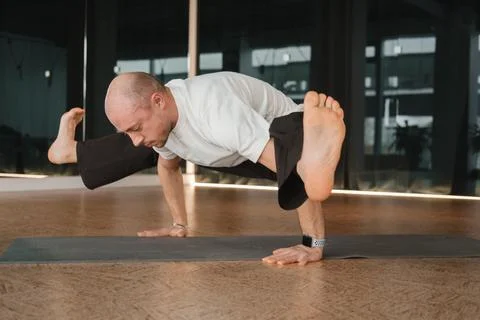 An athletic young man does exercises in the fitness room. A professional guy  Stock Photos