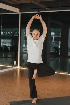 An athletic young man does exercises in the fitness room. A professional gu.. Stock-Fotos