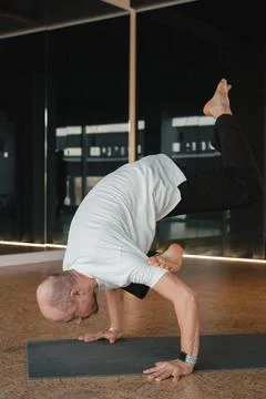 An athletic young man does exercises in the fitness room. A professional guy Stock Photos