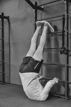 Athletic young man doing exercise for abdomen on vertical bar in gym or fitne Foto stock