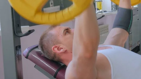 Athletic young man doing exercises with barbell at gym, fitness club Stock Footage