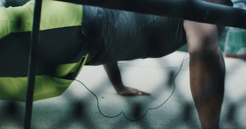 Athletic young man doing push ups while listening to music Stock Footage 85489197
