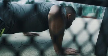 Athletic young man doing push ups while listening to music Stock Footage 85510138