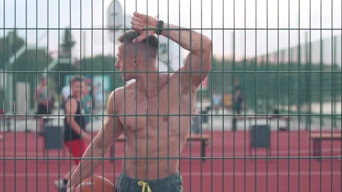 Athletic young man looking away at the at the basketball court next to the me Видео 159478597