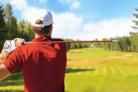 Athletic young man playing golf in golfclub. Stock Photos