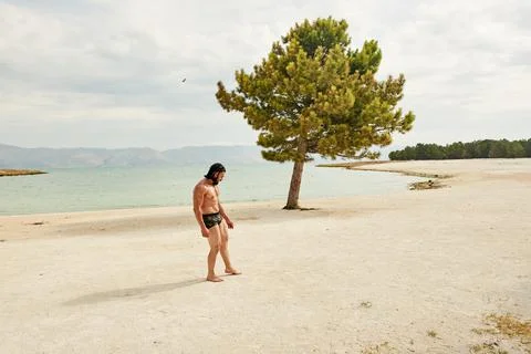 Athletic young man posing on the beach Stock Photos