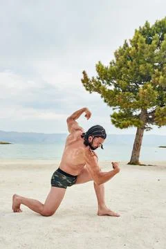 Athletic young man posing on the beach 写真素材