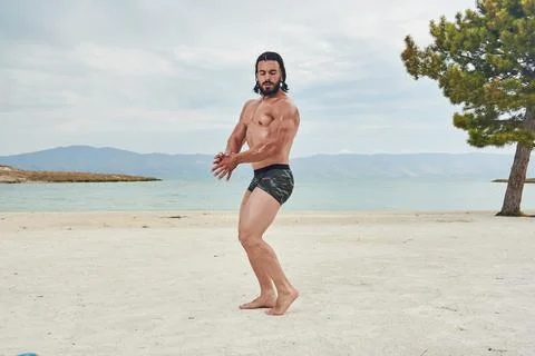 Athletic young man posing on the beach Stock-Fotos