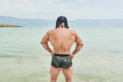 Athletic young man posing on the beach Fotos de archivo