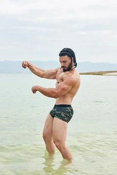 Athletic young man posing on the beach Foto stock