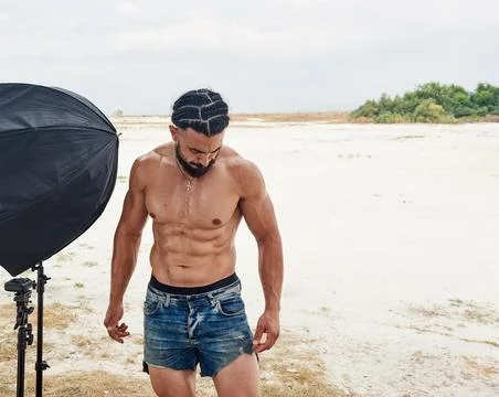 Athletic young man posing on the beach Stockfoto's