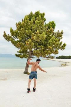 Athletic young man posing on the beach Stock Photos