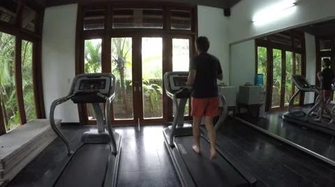 Athletic young man running 3 MPH miles per hour on treadmill bare footed 4k Stock Footage 55461136