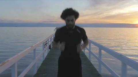 Athletic young man running on a pier at sunset Stock Footage 51466860