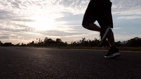 Athletic young man running on the road at sunset. Elderly men running for health Stock Footage 113617649
