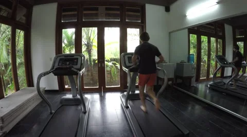 Athletic young man running on treadmill finishing then jumping off 4k Stock Footage 55461150