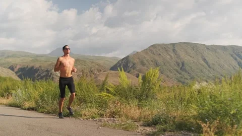 Athletic young man runs topless, muscles highlighted as he builds fitness. Video stock 301491889