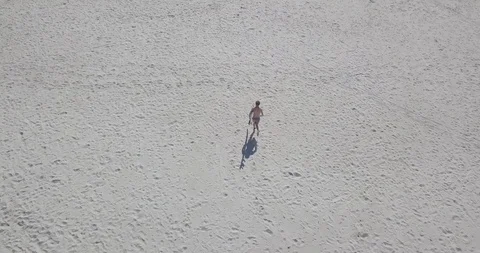 Athletic young man with a surfboard running to the sea Stock Footage 111770147