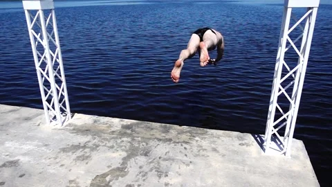 Athletic Young Man in Swim Briefs Standing on the Edge of a Concrete Pier Stock Footage 329966367
