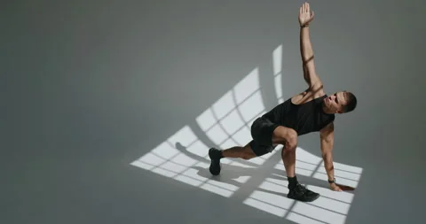 Athletic Young Man Training in Studio with Dramatic Lighting Stock Footage 344277080