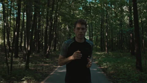 Athletic young man trains for marathon run in park Stock Footage 201236421