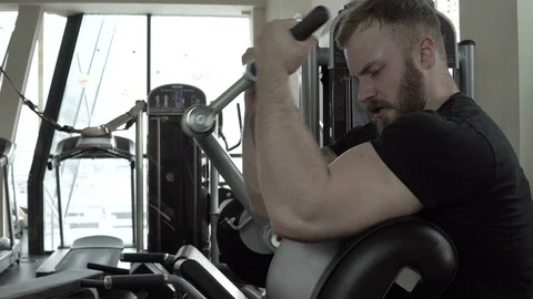 Athletic young man working out on fitness exercise equipment at gym. Stock Footage 85714976