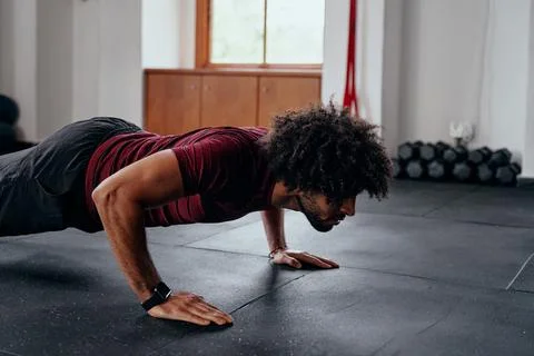 Athletic young middle eastern man doing push-ups at the gym Stock Photos