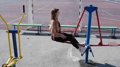 Athletic young student performing leg press exercises on outdoor gym equipment Video stock 347220237