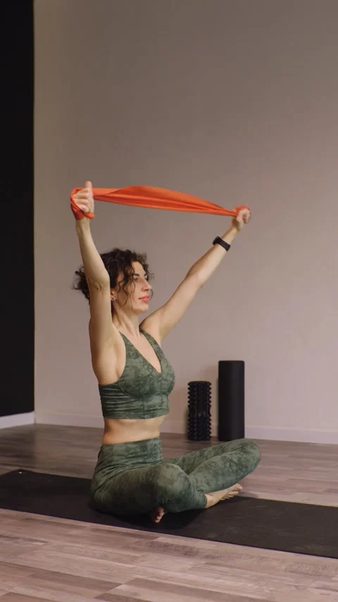An athletic young woman doing exercises using an elastic band in a studio. Stock-Footage 301809367