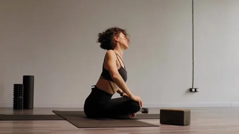 An athletic young woman doing exercises on a mat in a studio. Stock Footage 304579684