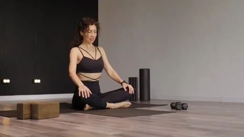 An athletic young woman doing exercises on a mat in a studio. Video stock 304579871