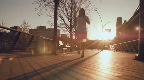 Athletic Young Woman Jogging in City Park Tracking Shot Stock Footage