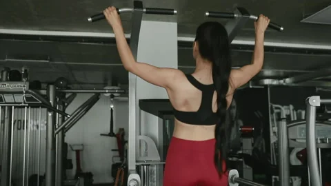 Athletic young woman pulling up on horizontal bar at gym Stock Footage 133703004