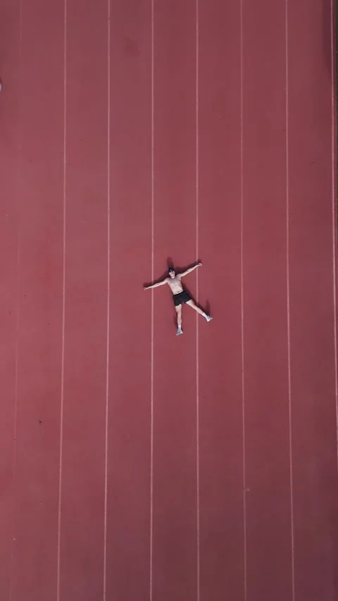 Athletics track from above, a runner throws himself on the ground in the mi.. Stock Footage 267894400