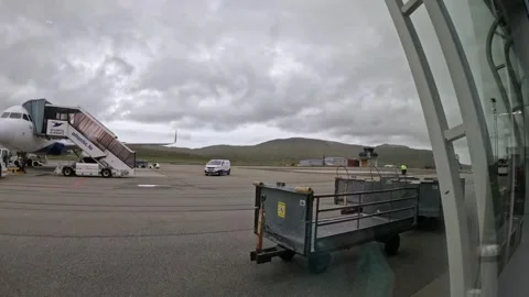 Atlantic Airways plane on apron as a jet takes off over mountain landscape Stock Footage 340183750