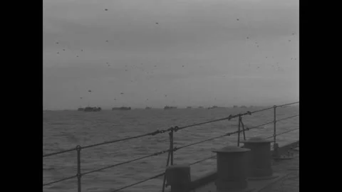 ATLANTIC OCEAN - 1944 - Barrage balloons fly over a fleet of invasion crafts Stock Footage 313209571