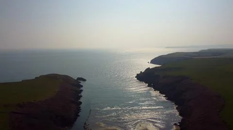 Atlantic Ocean cliffs with sun glare in drone flight over Stradbally Cove, Co Stock Photos