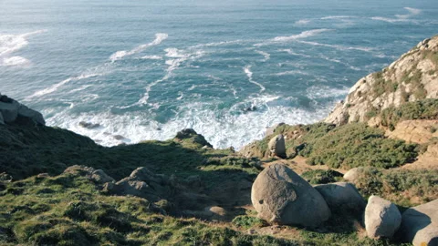 Atlantic Ocean hitting the rocky cliffs on a winter day. Rocks and grass in betw Video stock 170437294
