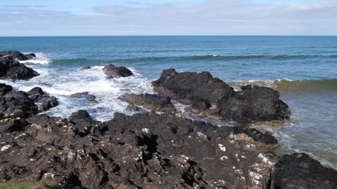 Atlantic Ocean waves crash dark rocks Portballintrae Northern Ireland Vídeos de archivo 304992236