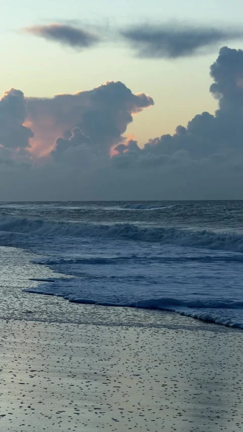 Atlantic ocean waves gently washing onto the sandy shore at golden sunset Video stock 333820286