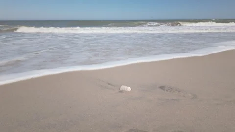 Atlantic ocean waves lap golden sands in real time and low angle Stockbeeldmateriaal 337180586