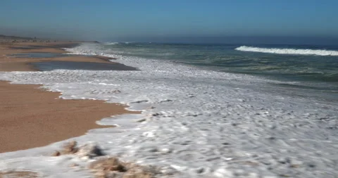 Atlantic Ocean Waves Rolling onto a Sandy Beach in Portugal Stock Footage 346035969