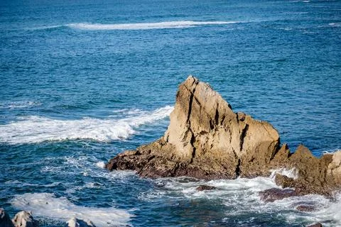 Atlantic waves breaking around isolated sea stack Foto stock