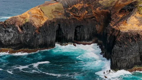 Atlantic waves enter narrow rocky inlet below steep volcanic cliffs Stock Footage 340069418