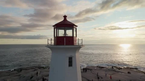 Atlantic Waves Hit Rocks Below Peggys Cove Lighthouse In Sunset Drone Video Stock Footage 314464387