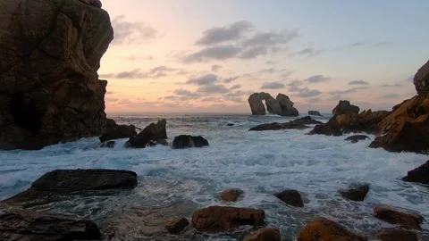 Atlantic waves roll into a rugged rocky cove during sunset on the northern .. Stock Footage 343227488