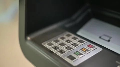 The ATM shows a close-up view of a keypad with buttons for withdrawing cash and Stock-Footage 337555956