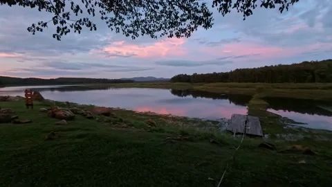 The atmosphere by the river in the evening offers a view of mountains and forest Video stock 337286710